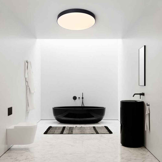 Plafonnier LED rond noir au plafond, diffuseur clair et lumière douce