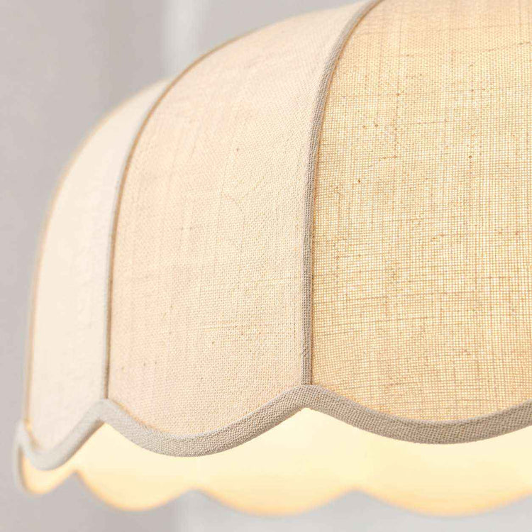 Détail de l’abat-jour en lin crème, texture tissée et bord ourlé