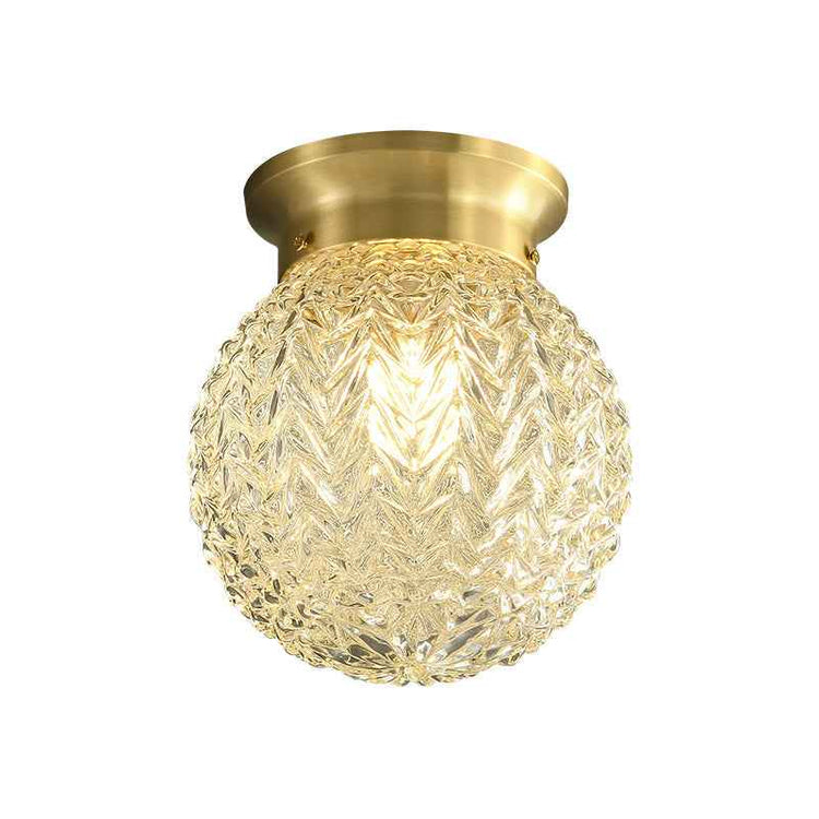Plafonnier semi-encastré: globe en verre texturé doré, vue rapprochée, monture laiton.