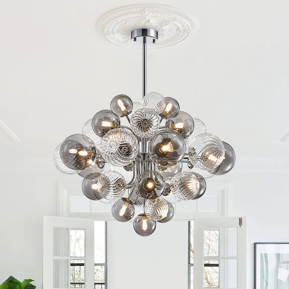 Lustre grappe en boules de verre, structure chromée et tige centrale suspendue.