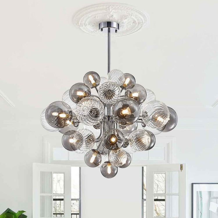 Lustre grappe en boules de verre, structure chromée et tige centrale suspendue.
