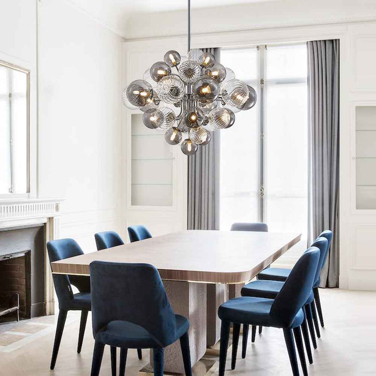 Lustre grappe suspendu avec nombreuses boules de verre et bras chromés.