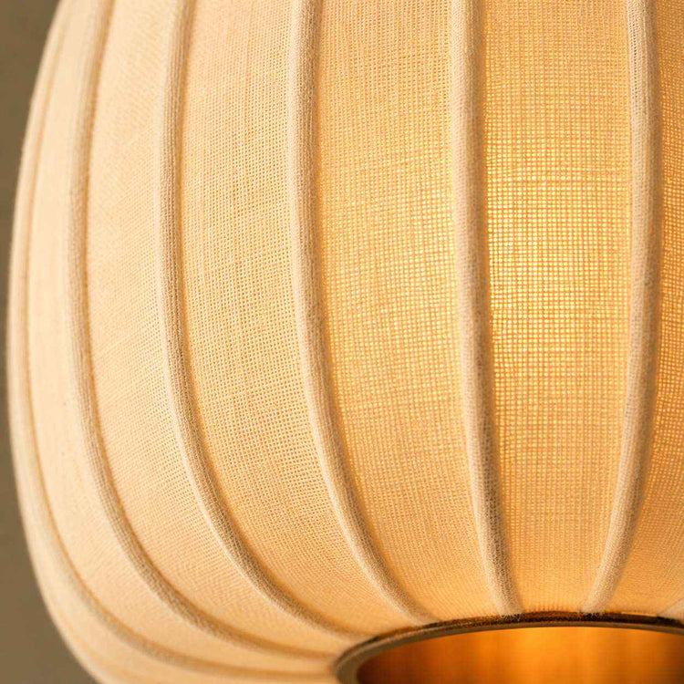 Gros plan sur l’abat-jour en lin côtelé beige avec texture tissée et rainures