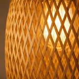 Abat-jour en rotin tissé ajouré, motif chevron, couleur miel, vue rapprochée.
