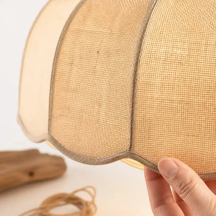 Détail du bord ondulé en lin crème et de la texture tissée de l’abat-jour