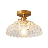 Plafonnier 1 lumière, dôme en verre transparent à bords ondulés, finition dorée.