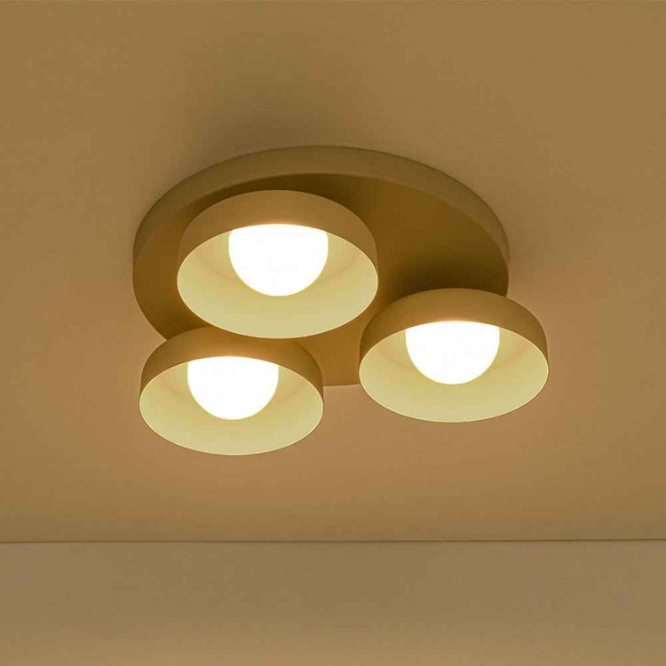 Plafonnier LED à 3 abat-jour beiges avec trois lumières allumées, forme arrondie.