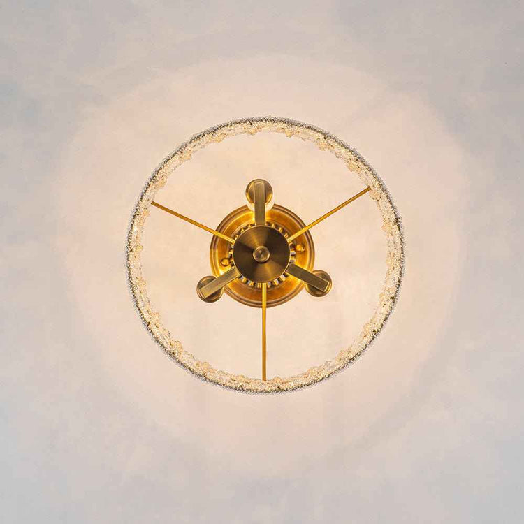Plafonnier en cristal et laiton : fixation centrale et bras décoratifs au plafond.