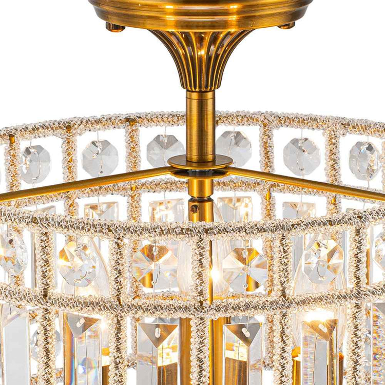 Plafonnier cristal laiton : support central doré et cadre en cristaux.