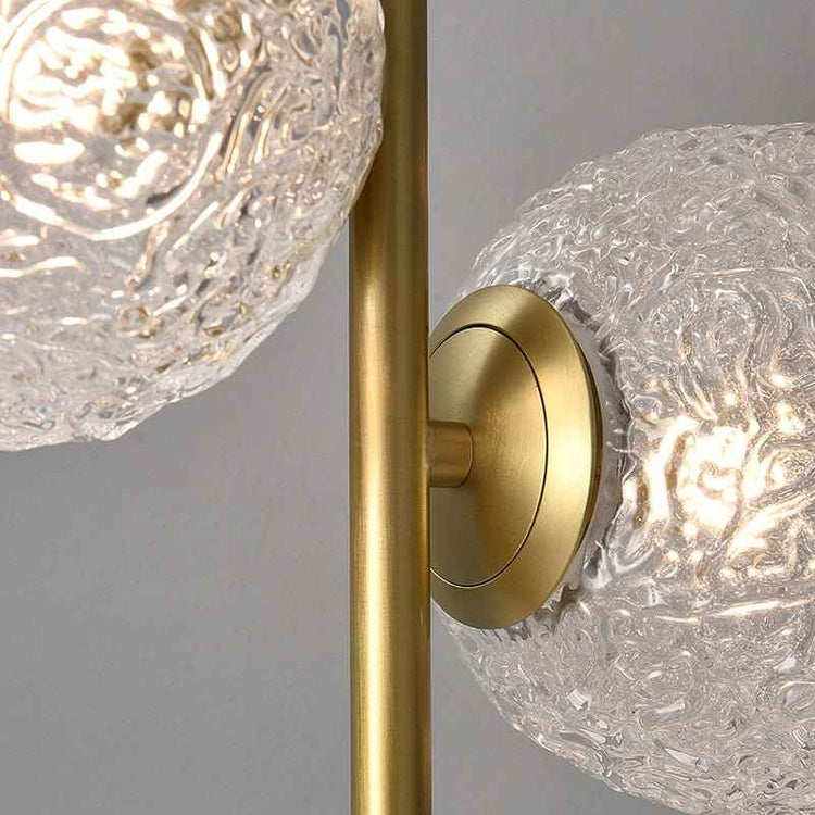 Lampe à poser : détail du globe en verre texturé et du support circulaire laiton doré.
