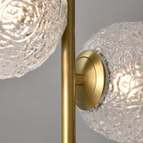 Lampe à poser : détail du globe en verre texturé et du support circulaire laiton doré.