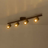 Plafonnier 4 spots sur rail bois noyer, spots allumés, vue sur le plafond.