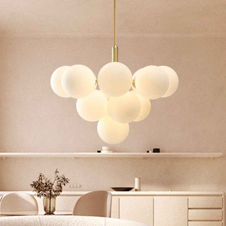 Lustre suspendu à boules en verre opale laiteux sur tige laiton, grappe décorative.