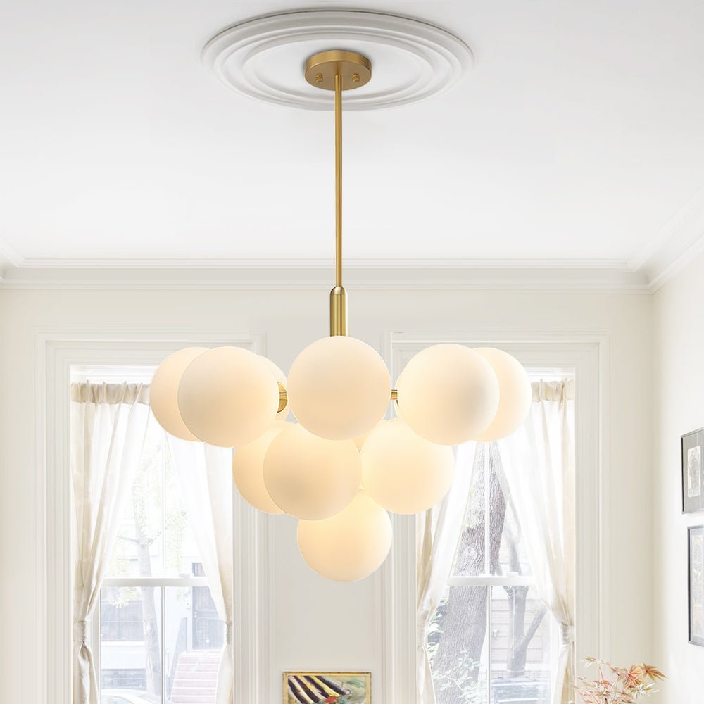 Lustre suspendu à plusieurs boules en verre opale laiteux, monture laiton au plafond.