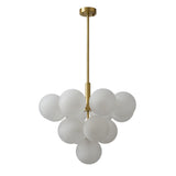 Suspension boules verre opale blanc texturé, monture laiton et tiges verticales.