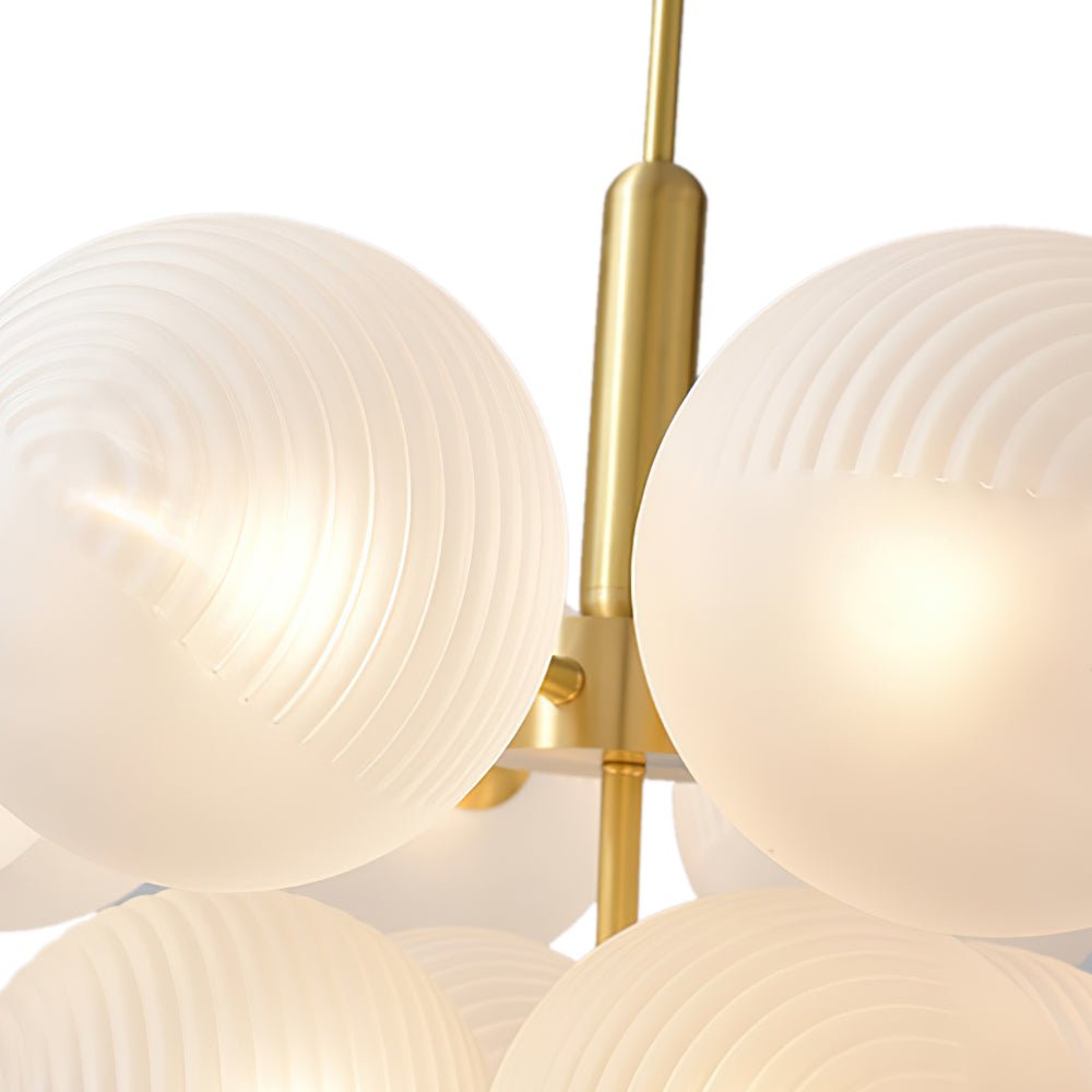 Boule en verre opale blanc texturé sur monture laiton, gros plan tiges et globes.