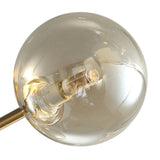 Globe en verre ambré du plafonnier, douille et ampoule visibles, monture dorée.
