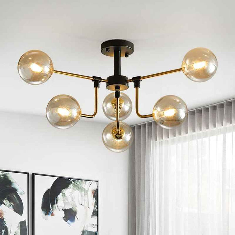 Plafonnier 6 lumières verre ambré, bras dorés et base noire au plafond.