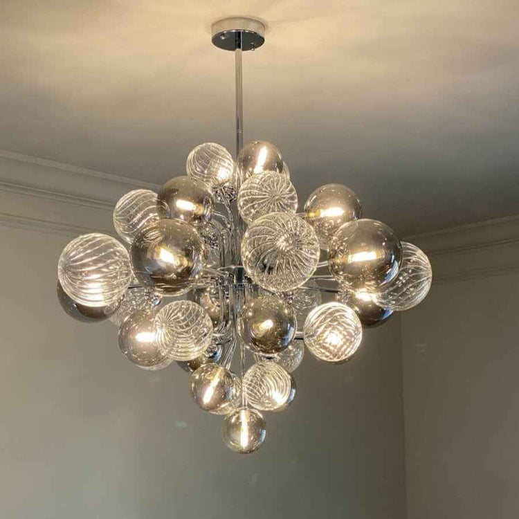 Lustre à boules de verre dorées et transparentes, nombreux globes sur tige centrale.
