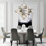 Lustre en grappe avec boules de verre transparentes, monture argentée, style décoratif.