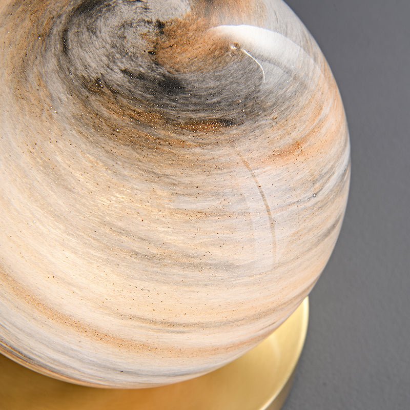 Globe en marbre beige et gris avec veines, détail près de la base