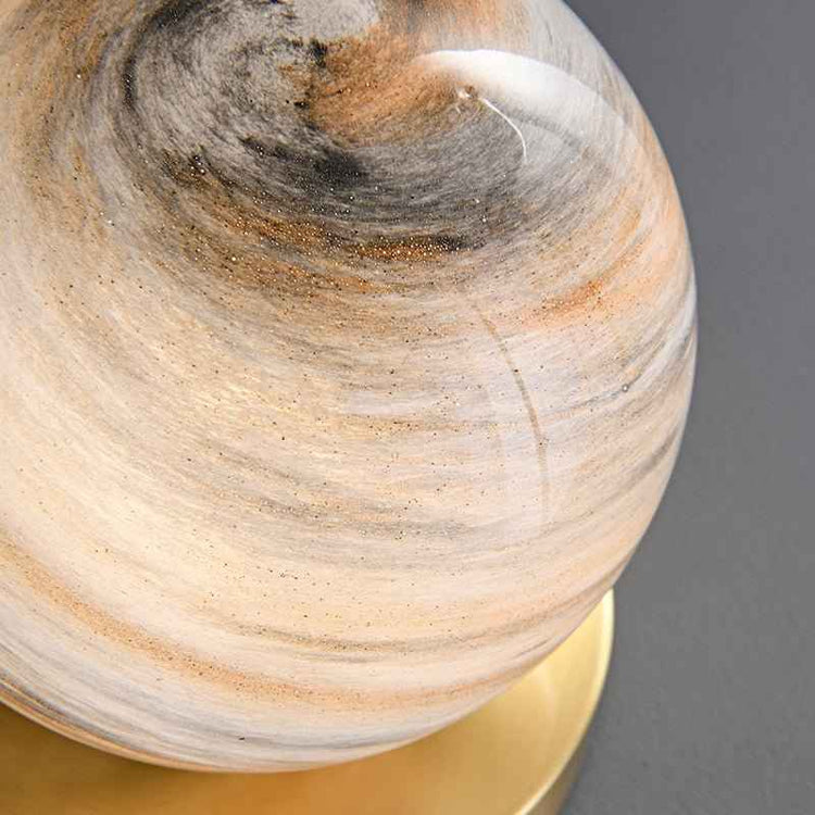 Globe en marbre beige et gris avec veines, détail près de la base