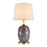 Lampe à poser en céramique gris foncé avec abat-jour en tissu beige et pied laiton