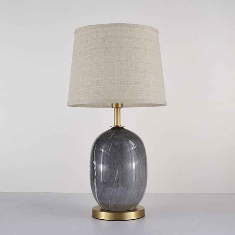 Lampe à poser avec abat-jour tissu beige et base céramique gris marbré, piètement laiton