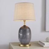 Lampe à poser avec abat-jour tissu beige et base en céramique gris foncé, piètement laiton