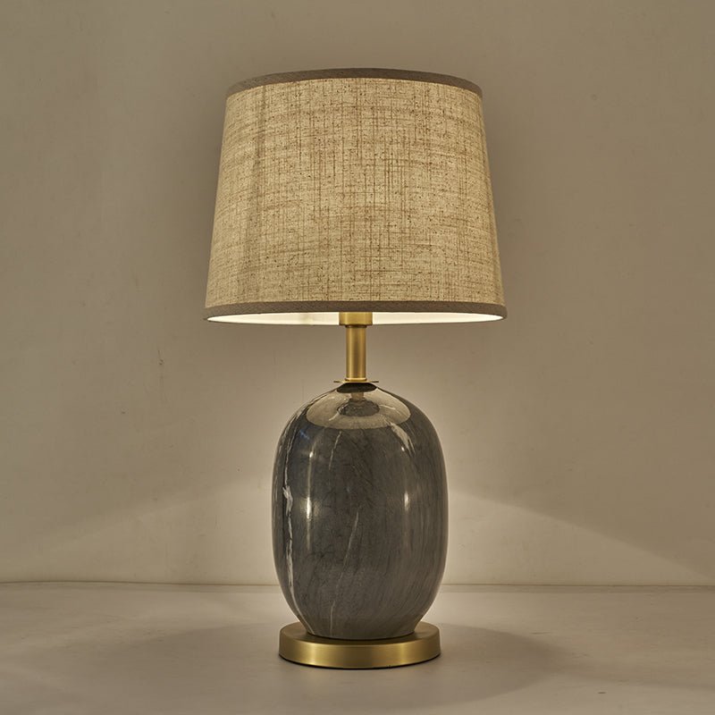 Lampe à poser avec abat-jour tissu beige texturé et base en céramique gris, socle laiton