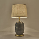 Lampe à poser avec abat-jour tissu beige texturé et base en céramique gris, socle laiton