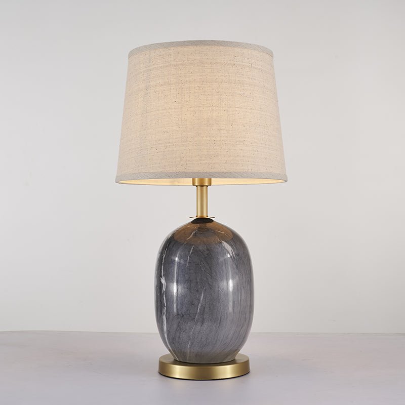 Lampe à poser avec abat-jour tissu beige et base en céramique gris foncé, finitions laiton