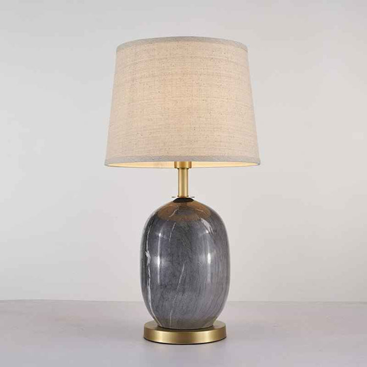 Lampe à poser avec abat-jour tissu beige et base en céramique gris foncé, finitions laiton