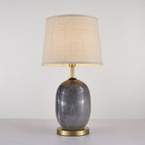 Lampe à poser avec abat-jour tissu beige et base en céramique gris foncé, finitions laiton