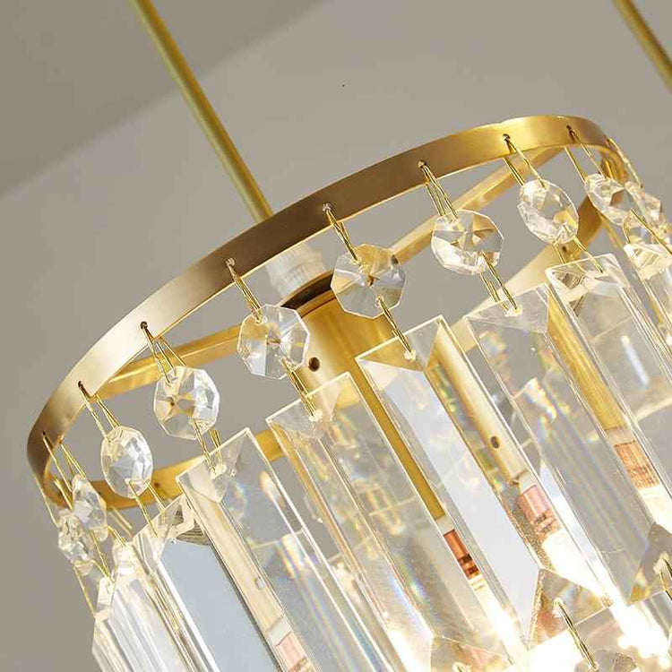 Détail d’une suspension cylindrique : monture dorée et cristaux transparents