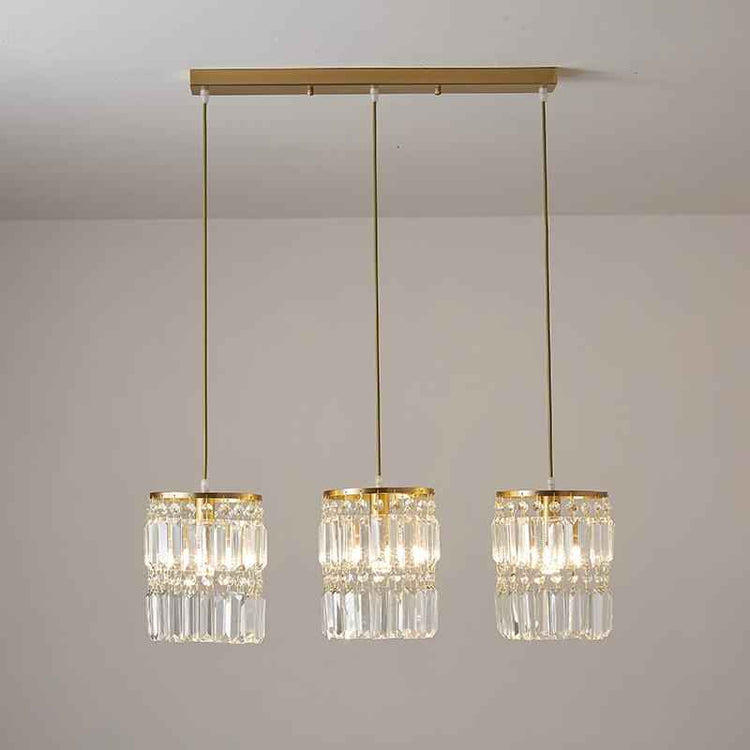 Suspension 3 lumières : trois abat-jour cylindriques en cristal, base et tiges dorées
