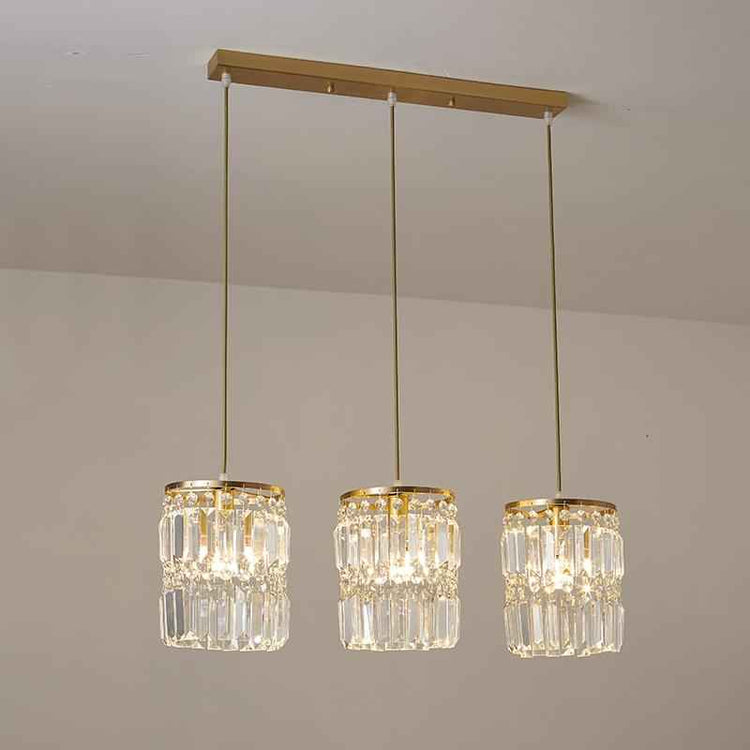 Suspension 3 lumières en cristal : abat-jours cylindriques et finitions dorées