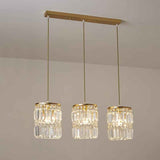 Suspension 3 lumières en cristal : abat-jours cylindriques et finitions dorées