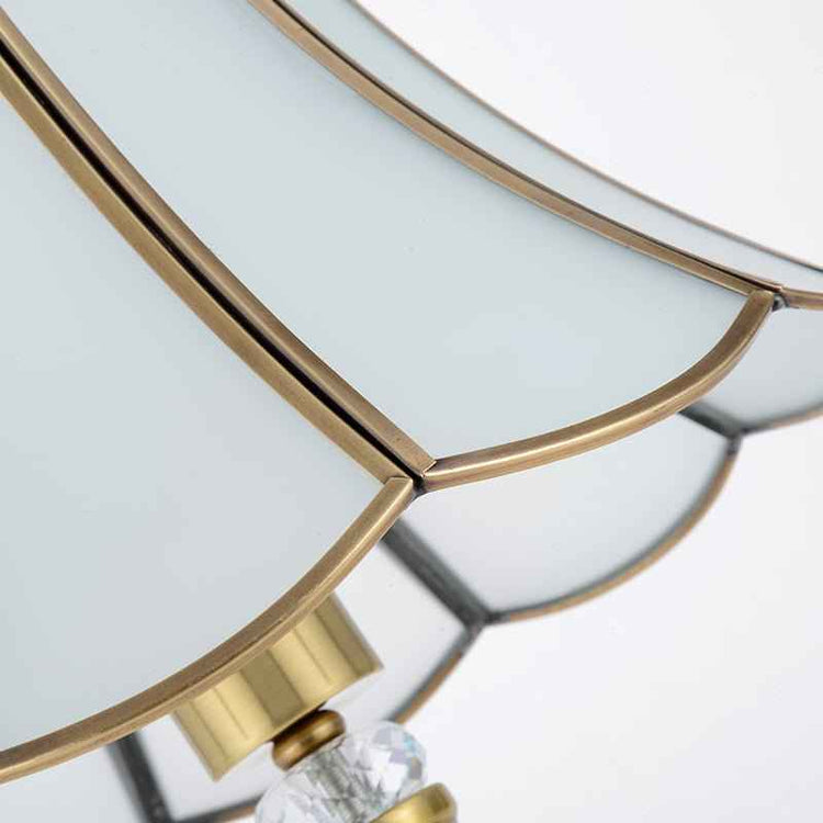 Base de lampe dorée avec élément central en cristal transparent et supports métalliques.