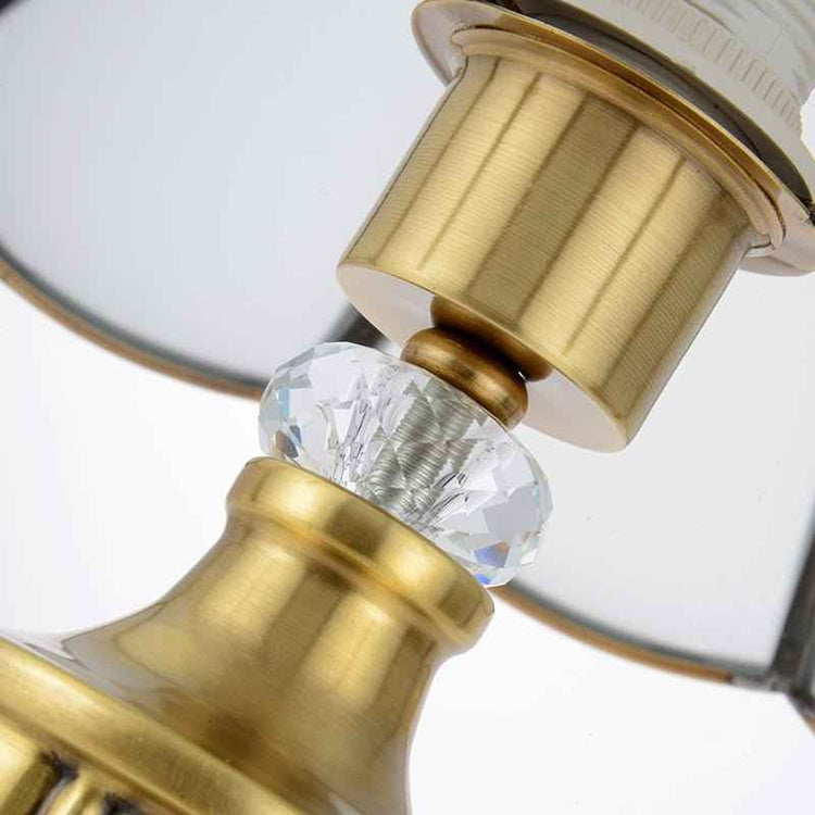 Ornement de lampe doré avec perle en cristal taillé sous l’abat-jour.