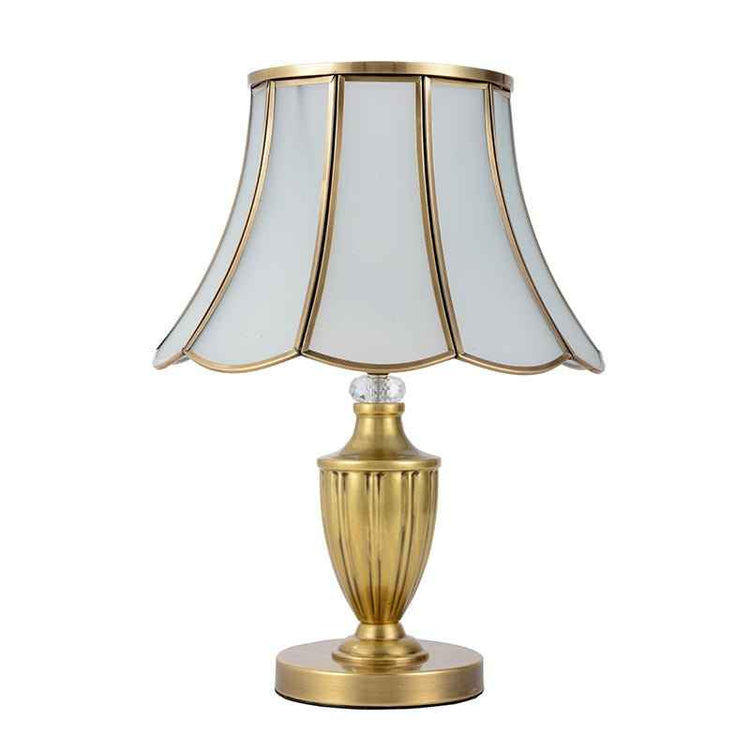 Lampe à poser dorée avec abat-jour évasé octogonal à bords festonnés.