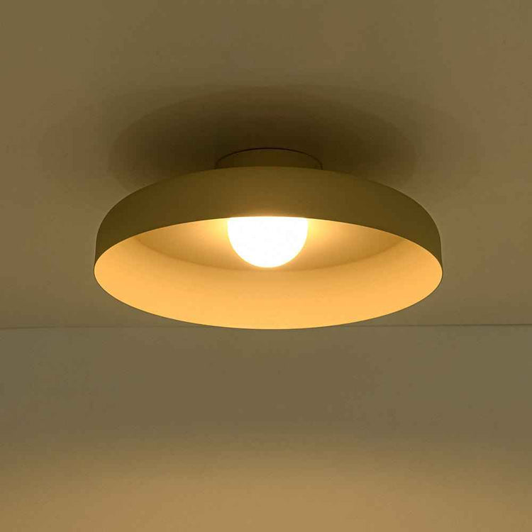 Plafonnier LED dôme beige allumé, abat-jour semi-encastré, lumière chaude.