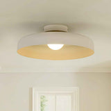 Plafonnier LED à abat-jour dôme beige, semi-encastré, ampoule allumée.