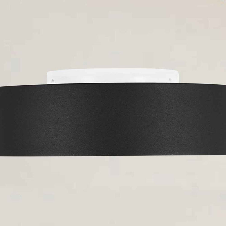 Abat-jour noir du plafonnier LED, bordure dorée et diffuseur blanc partiellement visible.