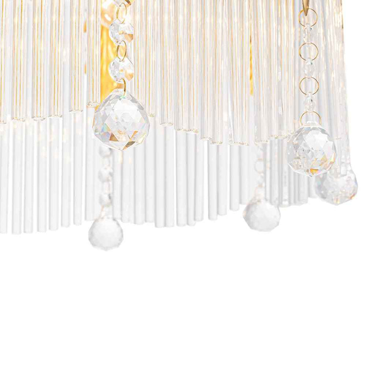Pendentifs en cristal transparents et franges blanches d’un lustre doré.