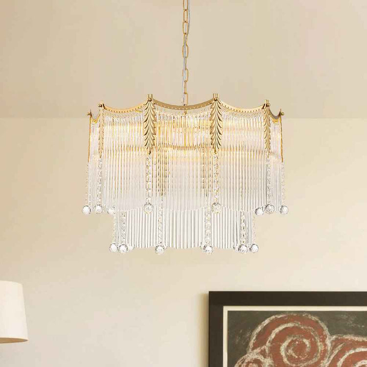Lustre en cristal suspendu, monture dorée ajourée, franges blanches et gouttes.