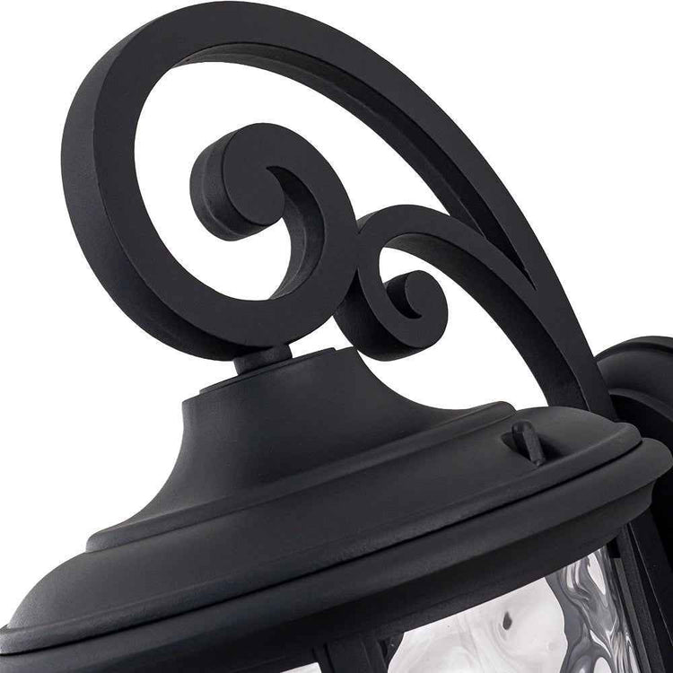 Applique extérieure lanterne IP23, volutes décoratives noires au-dessus du verre transparent.