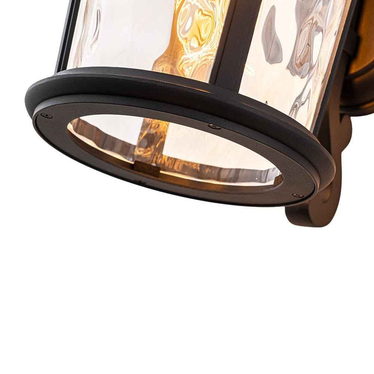 Applique extérieure lanterne IP23 : base circulaire noire et verre transparent.