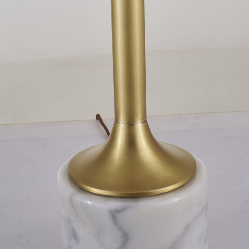 Pied doré et base en marbre blanc veinuré de la lampe à poser.