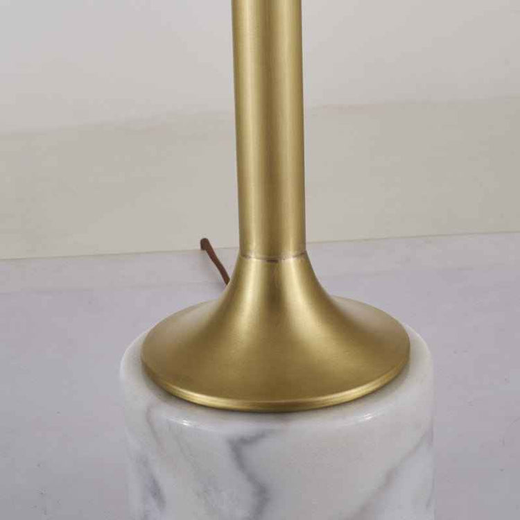 Pied doré et base en marbre blanc veinuré de la lampe à poser.